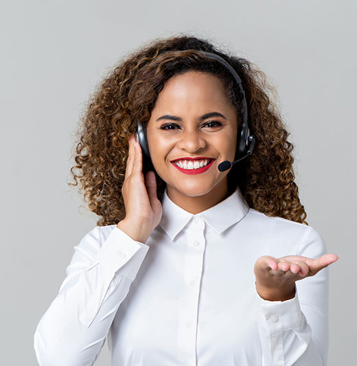 Smiling service minded African American woman wearing headphones as a call center staff studio shot on light gray banner background with copy space