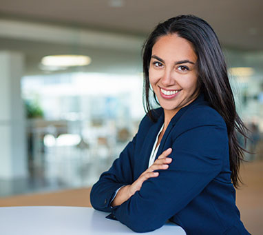 Cheerful young businesswoman. Beautiful happy young woman in formal wear sitting at table and smiling at camera. Emotion concept